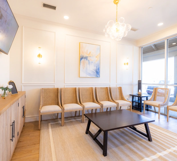 Modern dental waiting room with comfortable seating, wooden accents, and contemporary furniture.